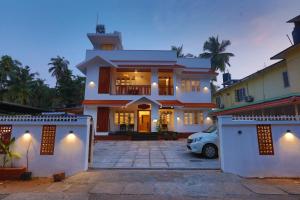 a house with a car parked in front of it at Choice Beach House in Kannur