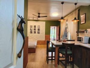 a kitchen and living room with a table and a dining room at Eco Farmstay Cottages #1 in Dharamshala