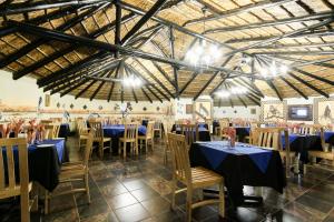 a banquet hall with blue tables and chairs at Zulu Nyala Heritage Safari Lodge in Hluhluwe