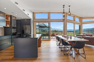 uma cozinha e sala de jantar com mesa e cadeiras em Vino and Views - Bannockburn Holiday Home em Cromwell