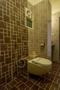 a tiled bathroom with a toilet and a shower at Hotel Metropolitan in Jaipur