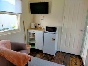 a small kitchen with a microwave and a refrigerator at Avonlea Cottages in York