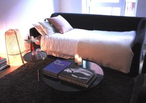 a living room with a bed and a table with a book at Privatzimmer - Zentral - Volksparkstadion - barrierefrei - Nahe A7 in Hamburg