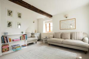 a living room with two couches and a table at Wye Valley Holiday Cottage - Field Cottage in Peterstow