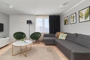 a living room with a gray couch and two green chairs at Kotlarska Market Square Apartment with Airconditioning by Renters in Wrocław