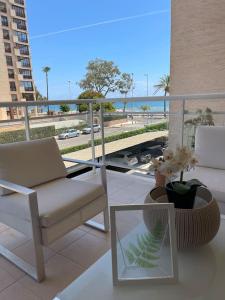 un balcón con una silla y un jarrón de flores en Seaside Apartment Retreat, en Benicàssim