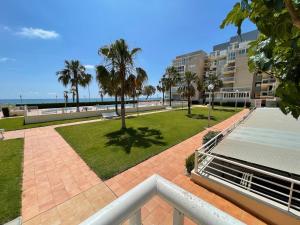 a view of a park with palm trees and a building at Seaside Apartment Retreat in Benicàssim