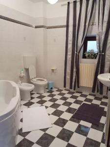 een badkamer met 2 toiletten en een geruite vloer bij Casa Milu - at your complete disposal in Mango