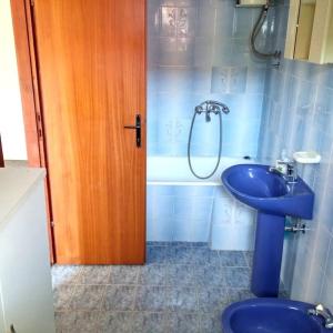 uma casa de banho com um lavatório azul e um chuveiro em Apartman PEGRE - NO A/C em Supetar