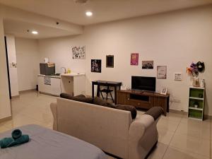 a living room with a couch and a television at TREFOIL@SETIA CITY, STUDIO UNIT,HOMESTAY in Shah Alam