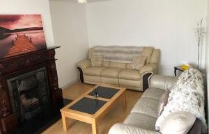 a living room with a couch and a coffee table at Cleomack House - Perfect for two in Hilltown