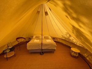 a tent with a bed in it with a table at Glamping Tält Mariehamn in Mariehamn