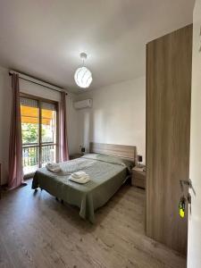 um quarto com uma cama e uma grande janela em hotel La pineta em Carrara