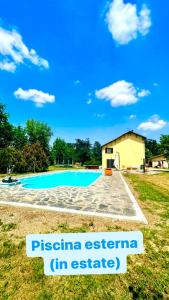 a swimming pool with a house in the background at Dormi nella SPA privata con letto ad acqua, sauna, doccia emozionale e kneipp in Alessandria