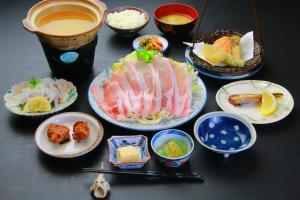 a table with plates of food and bowls of food at Family Ryokan Kawakyu with Showa Retro in Ibusuki