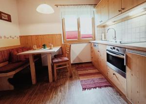 een keuken met een tafel en een wastafel bij Ferienhof Mittermair in Vorderstoder