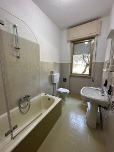 uma casa de banho com uma banheira, um WC e um lavatório. em hotel La pineta em Carrara