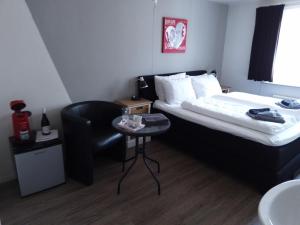 a hotel room with a bed and a chair at B&B De Goede Tijd in Thorn