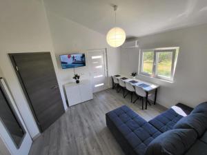 ein Wohnzimmer mit einem blauen Sofa und einem Tisch in der Unterkunft Lana in Bibinje