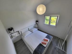 ein Schlafzimmer mit einem Bett mit zwei Kissen und einem Fenster in der Unterkunft Lana in Bibinje