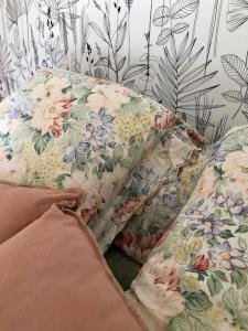 um sofá com um padrão floral na parede em La Petite Maison Nature em Saint-Jacques-des-Blats