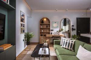 ein Wohnzimmer mit einem grünen Sofa und einem Tisch in der Unterkunft Relaxo Collection Luxury Suites in the Heart of Heraklion in Iraklio