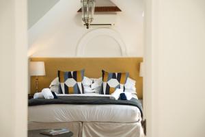 a bedroom with a bed with pillows on it at Les Chambres Guest House in Franschhoek