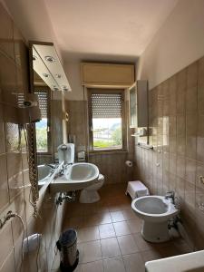 bagno con 2 lavandini, servizi igienici e specchio di hotel La pineta a Carrara