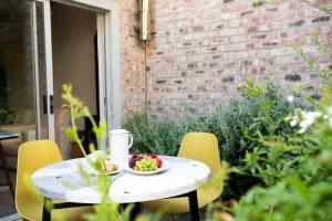 a white table with a bowl of fruit on it at Cottage Twelve14 in Wilderness