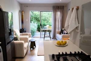 a living room with a kitchen and a living room with a table at Cottage Twelve14 in Wilderness
