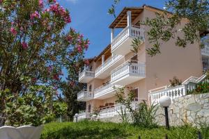 a building with white balconies and pink flowers at Corfu Panorama by Estia in Moraitika