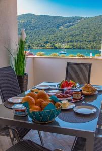 a table with a plate of food on it at Sea View Apartments in Grebaštica
