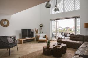 - un salon avec un canapé et une télévision dans l'établissement Schitterende Water Loft hartje centrum Harderwijk, à Harderwijk