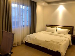 金邊的住宿－Yaou Hotel，一间卧室设有一张大床和一个窗户。