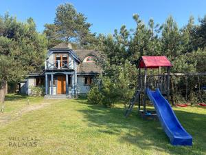 a playground with a slide in front of a house at Villa Las Palmas in Matyldów
