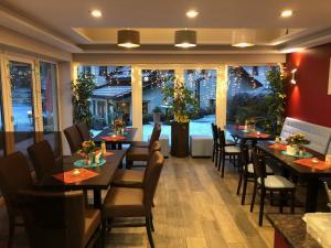 ein Restaurant mit Tischen und Stühlen und einem großen Fenster in der Unterkunft Hotel & Gasthaus Sterngrund in Zella-Mehlis