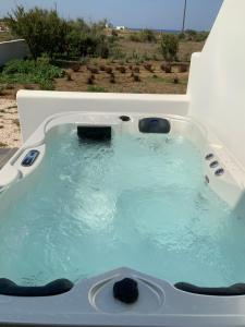 a bath tub filled with blue water in front of a window at Villa NanSea in Kastraki