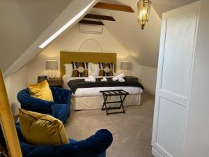 a bedroom with a bed and a blue chair at Les Chambres Guest House in Franschhoek +92 photos
