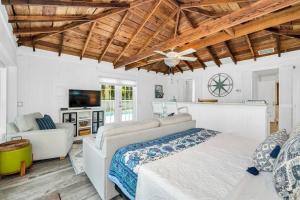 a bedroom with a bed and a couch and a tv at Cabin Style Pool Home w/ Guesthouse! Sleeps 10! in Stuart +51 photos