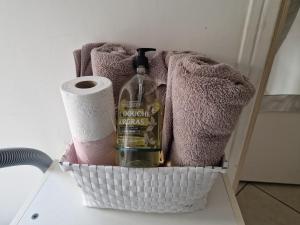 a basket with a bottle of wine and toilet paper at Le Cosy - Hyper Center 2 room apartment in Nice