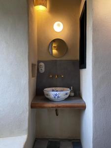 a bathroom with a bowl sink and a mirror at Torra di Ciocce in Pino
