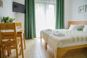 Un dormitorio con una cama y un escritorio y una ventana. en Cudne Manowce, en Wisła