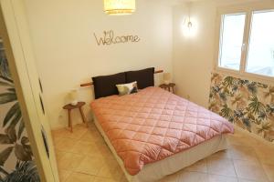 - une chambre avec un lit et une couette rose dans l'établissement CHEZ NOUCETTE, à Saint-Cyr-sur-Mer