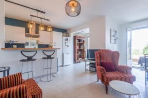 una cucina e un soggiorno con sedie e bancone di U Momentu - appt climatisé avec terrasse a LʼÎle-Rousse