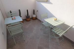 jadalnia z 2 stołami i krzesłami w obiekcie Casa Flora - Bed and Breakfast w mieście Torre San Giovanni Ugento
