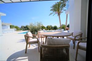 派亞的住宿－Luxury 4 Bedroom Oasis Villa，一个带桌椅的庭院和一个游泳池