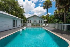 a swimming pool in front of a house at Cabin Style Pool Home w/ Guesthouse! Sleeps 10! in Stuart