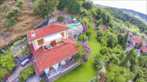 a house with a red roof and a swimming pool at Villa Romantica Sea View in Camaiore