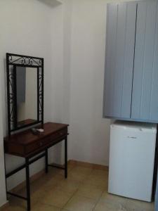 a mirror on a table next to a small refrigerator at Villa Murano in Fira