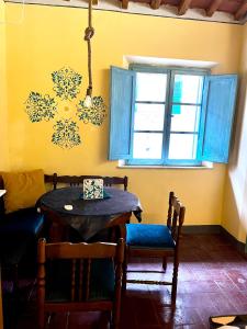 comedor con mesa, sillas y ventana en Turquoise Rose Apartment, en Peccioli